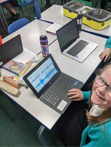 Child smiling up from computer
