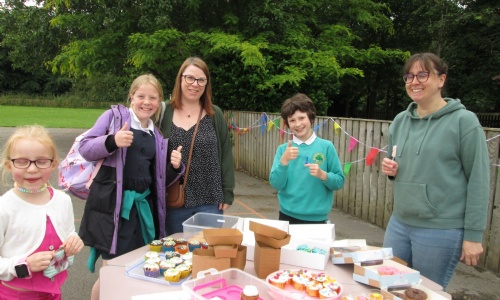 Parents and children with cake stall