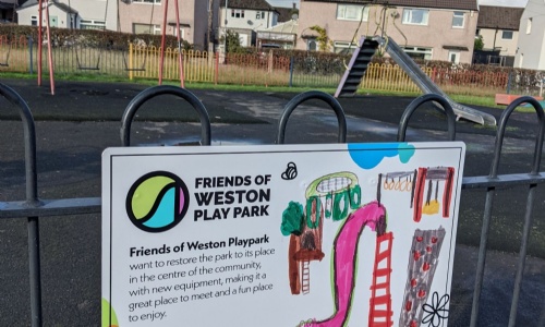 Friends of Weston Play Park signs on fence with children's drawings