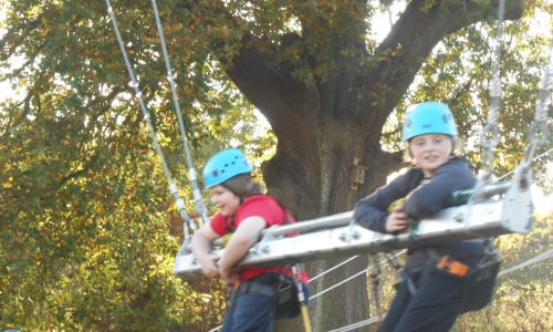 Two Children in crash helmets on the high swing