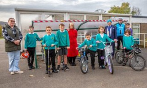 Children, teachers and Otley Cycle Club members in front of cycle shelter