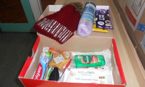 sample shoebox with toiletries and woolly hat